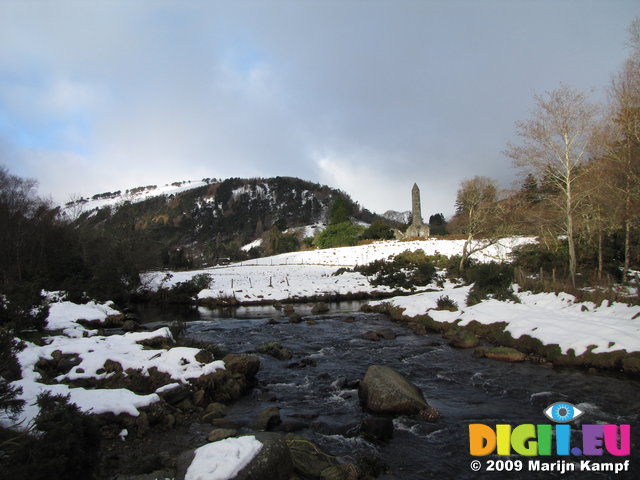 SX02580 Glendasan river in front of Round Tower Glendalough in snow